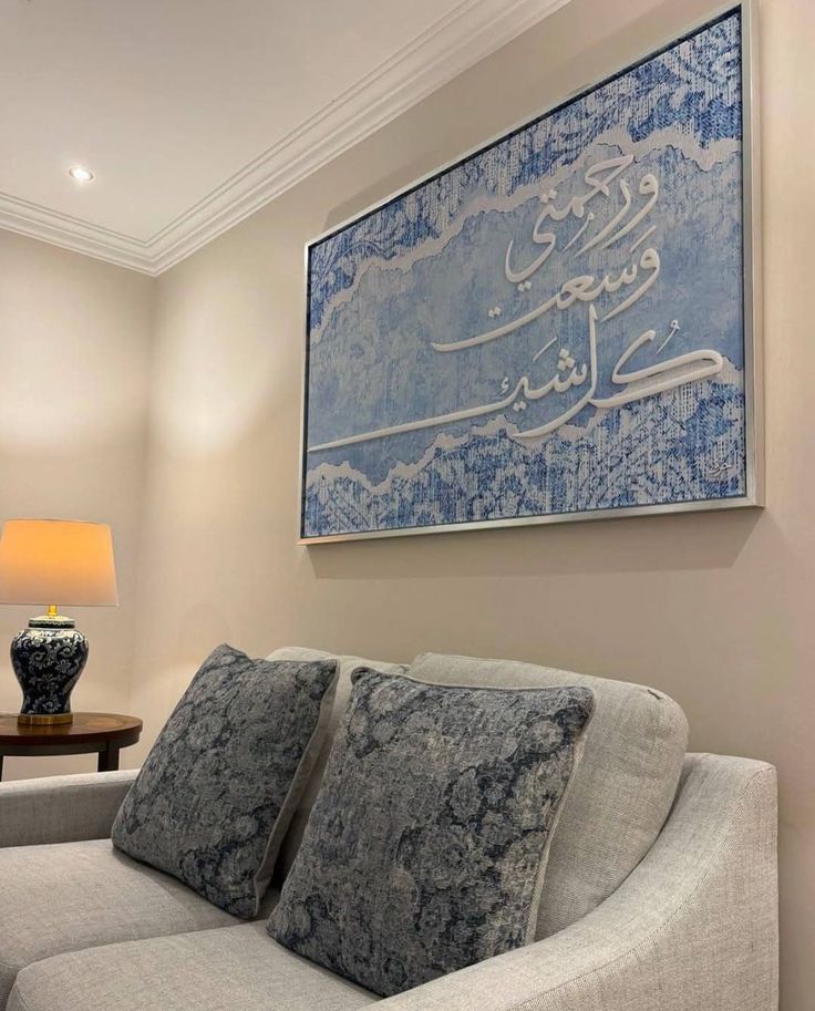 Soft ivory sitting room with blue calligraphic artwork and ceramic table lamp