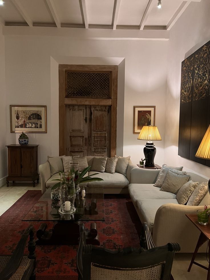 Layered heritage living room with an antique timber door, woven seating and a red rug