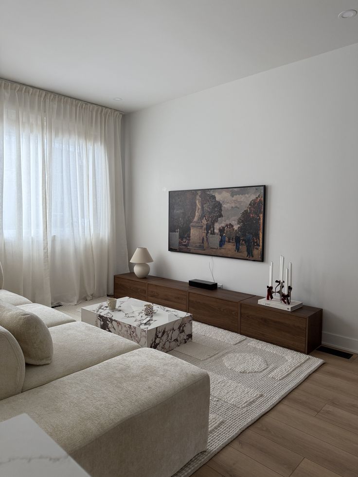 Light Scandinavian living room with an ivory sectional, walnut media storage and a stone coffee table